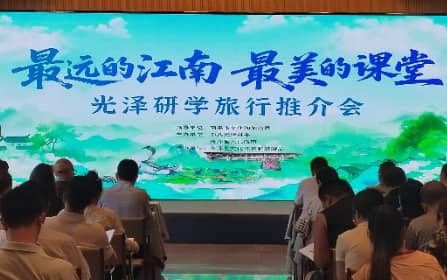 光泽研学旅行推介会现场,全景大屏呈现“最远的江南 最美的课堂”主题,来宾就座聆听